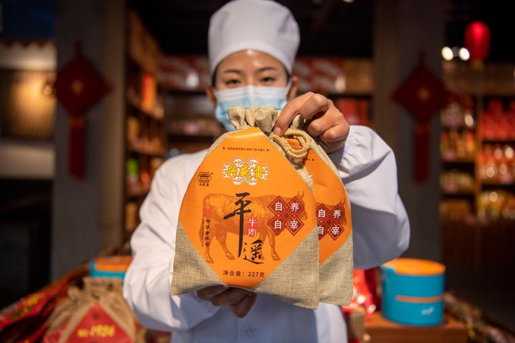 1月27日，在平遙古城南大街的一家平遙牛肉店內(nèi)，工作人員展示一款牛肉產(chǎn)品。新華社記者 楊晨光 攝