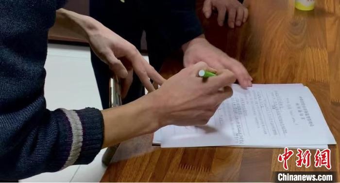 圖為現(xiàn)場下達詢問通知書。　李婷婷 攝