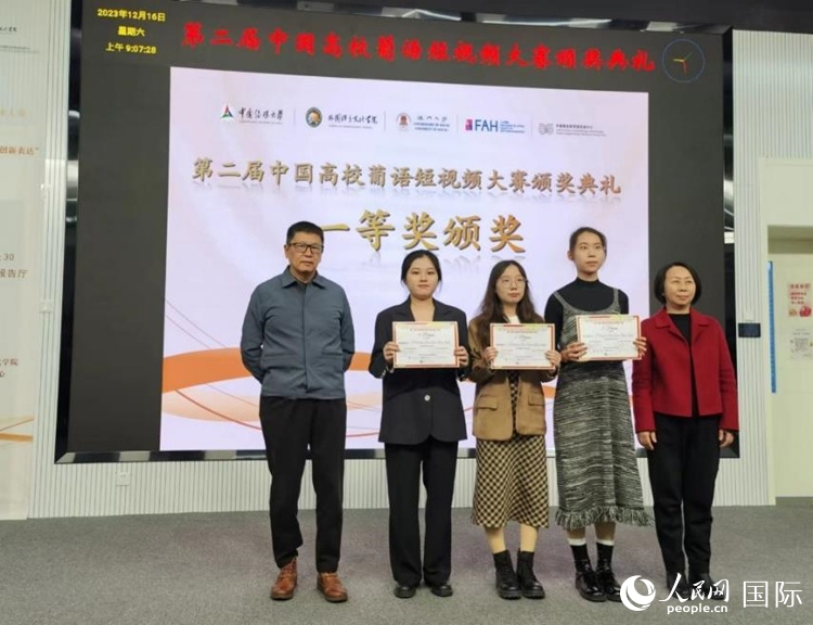 澳門大學中葡雙語教學暨培訓(xùn)中心主任姚京明（左一）和中國傳媒大學外國語言文化學院院長文春英（右一）為一等獎獲得者頒獎。人民網(wǎng)記者 魯揚攝