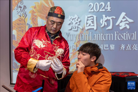 1月28日，在上海豫園舉行的民俗活動(dòng)上，美國(guó)馬斯卡廷中學(xué)學(xué)生在非遺傳承人的指導(dǎo)下吹糖偶。 新華社記者 王翔 攝