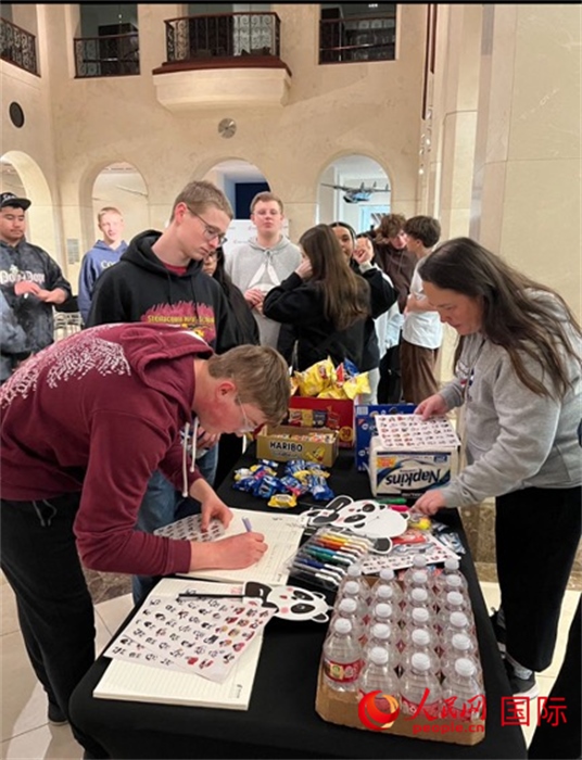 學(xué)生們出發(fā)前紛紛在留言簿留言。人民網(wǎng)記者 鄧圩攝