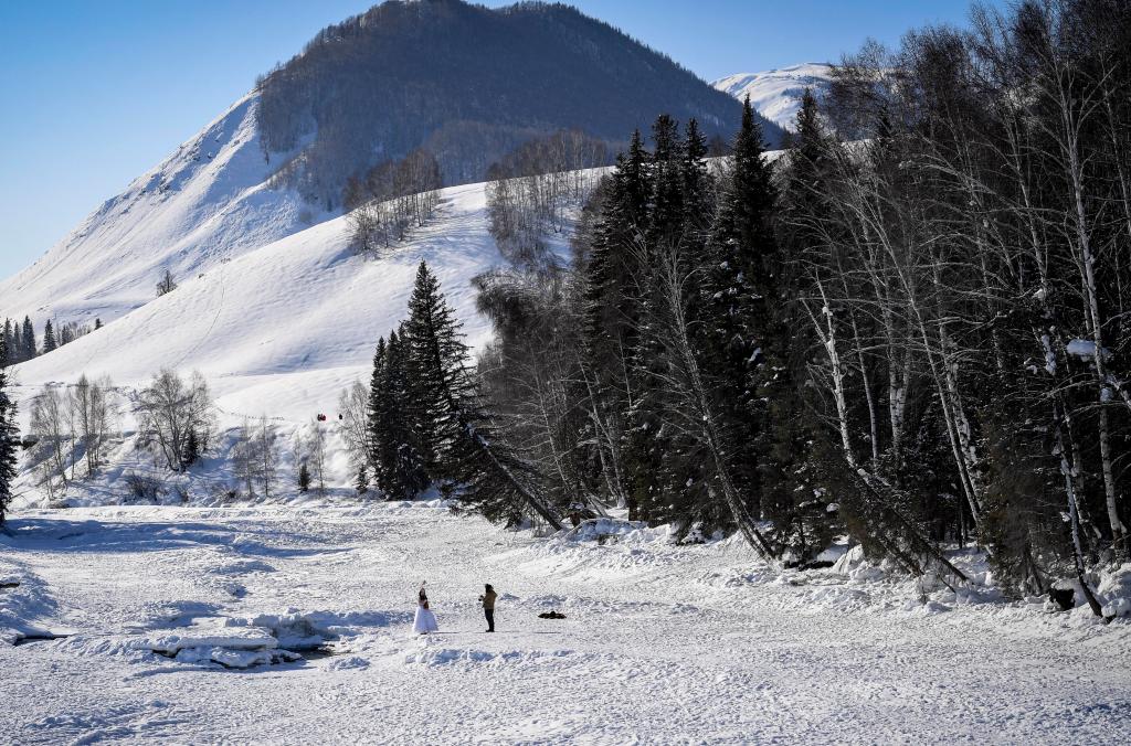 2024年2月5日，兩名游客在新疆阿勒泰地區(qū)布爾津縣禾木村拍照。新華社記者 馬鍇 攝